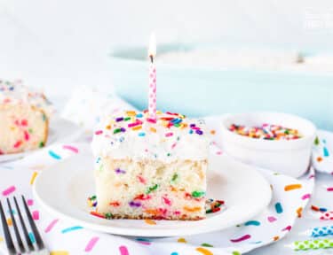 Birthday Candle on top of a slice of Funfetti Cake.