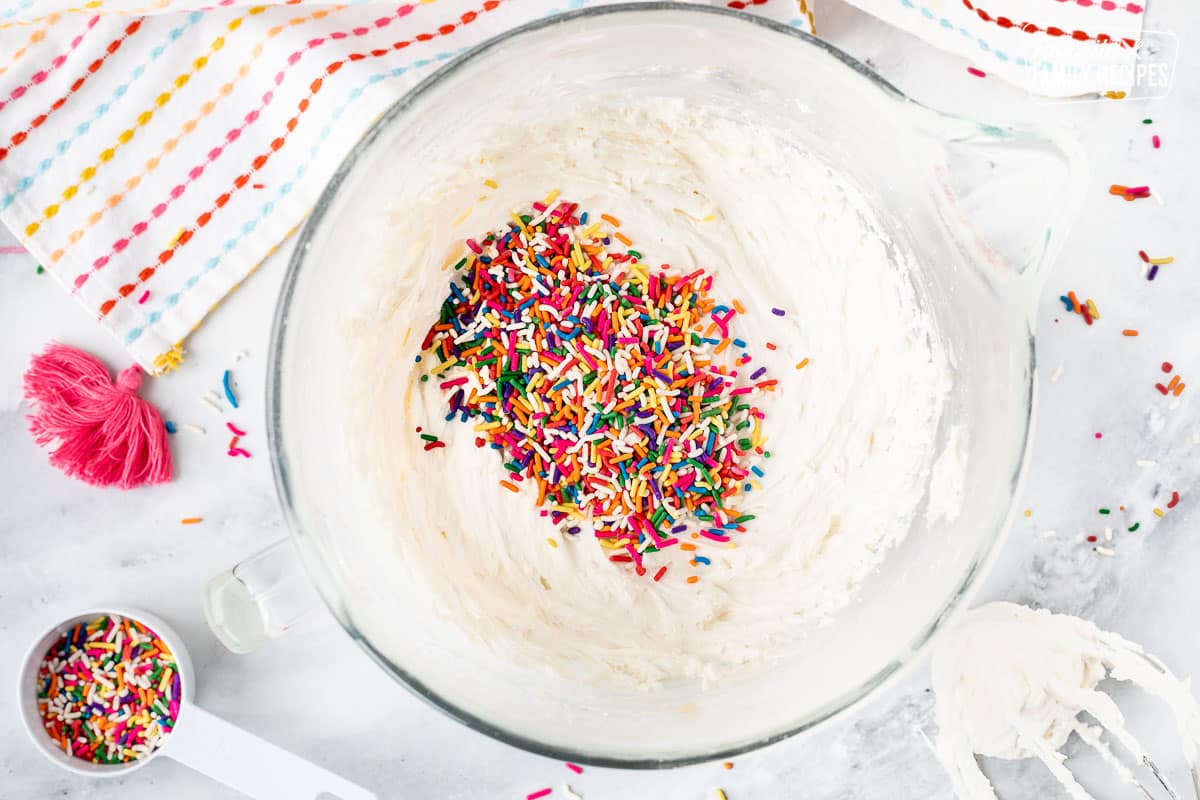 Mixing bowl with frosting and sprinkles.