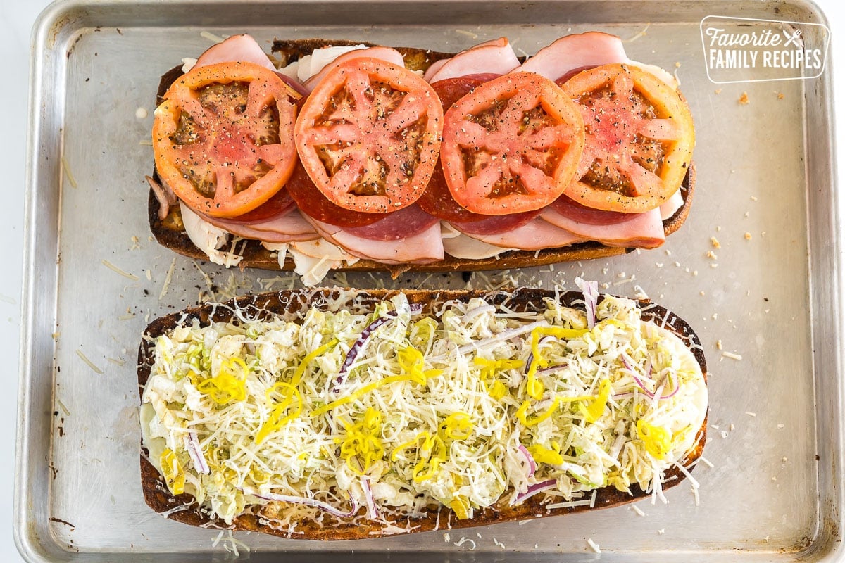 Toasted Italian loaf with ham, salami, pepperoni, turkey, provolone and parmesan topped with tomato slices, Grinder salad, and pepperoncinis.