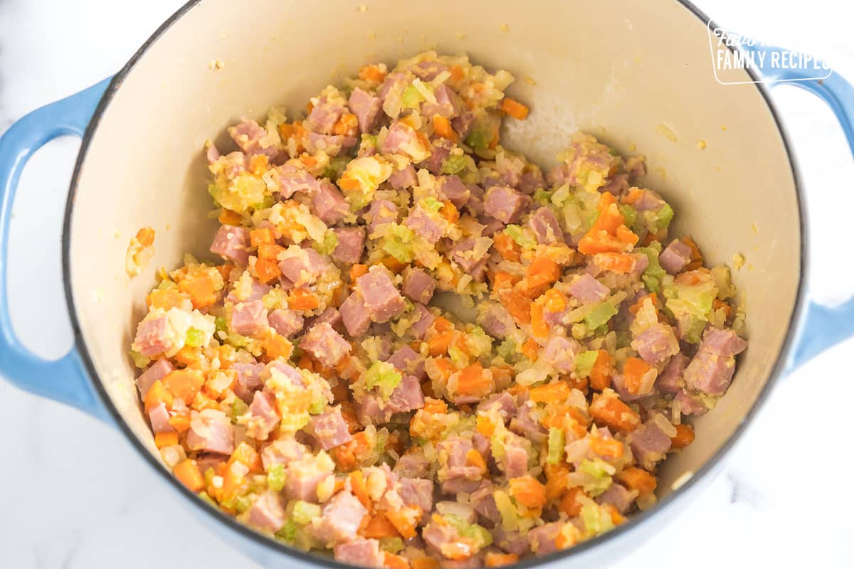 meat and veggies in a large pot with roux