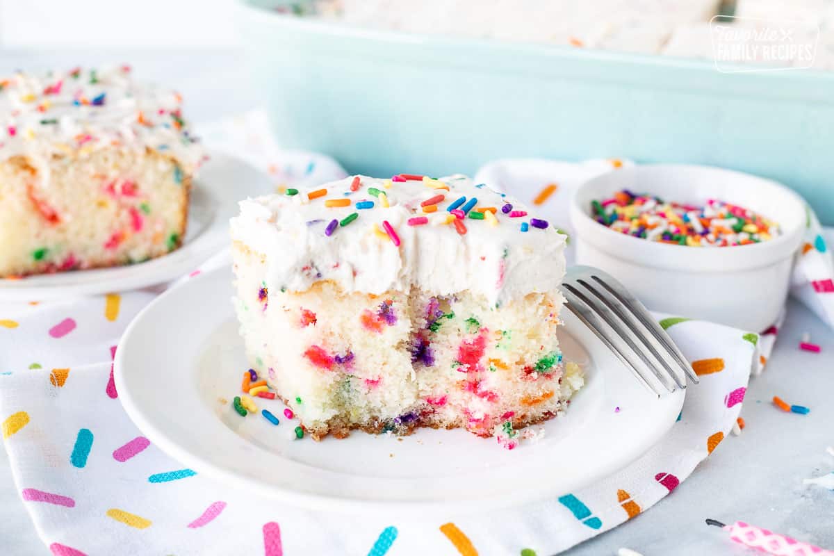 Slice of Frosted Funfetti Cake halved with sprinkles.