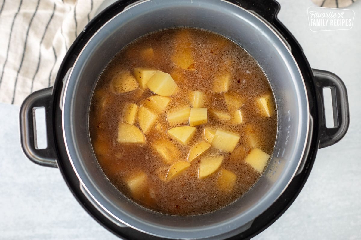 Instant Pot with broth and potatoes.