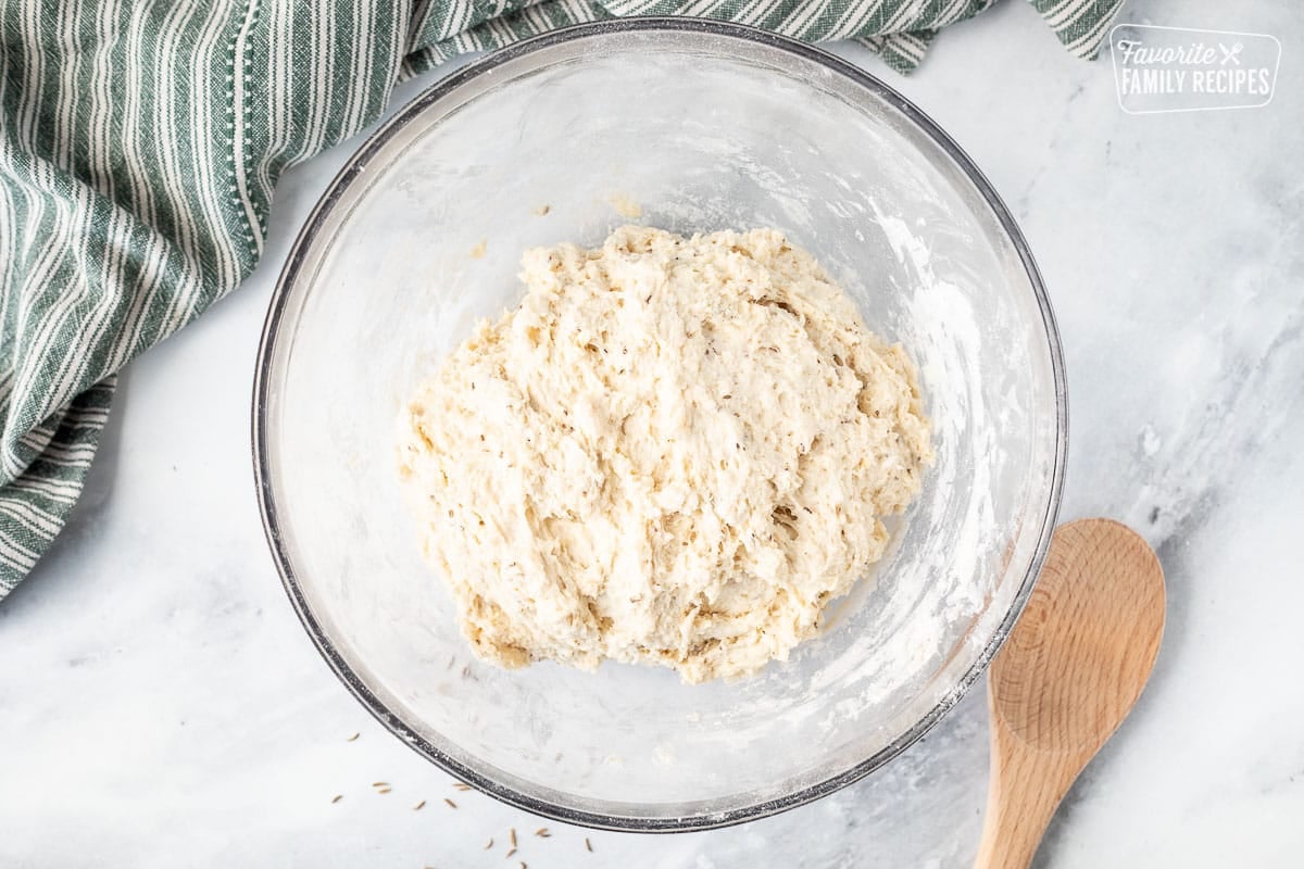 Bowl of sticky Irish Soda Bread dough. Wooden spoon on the side.