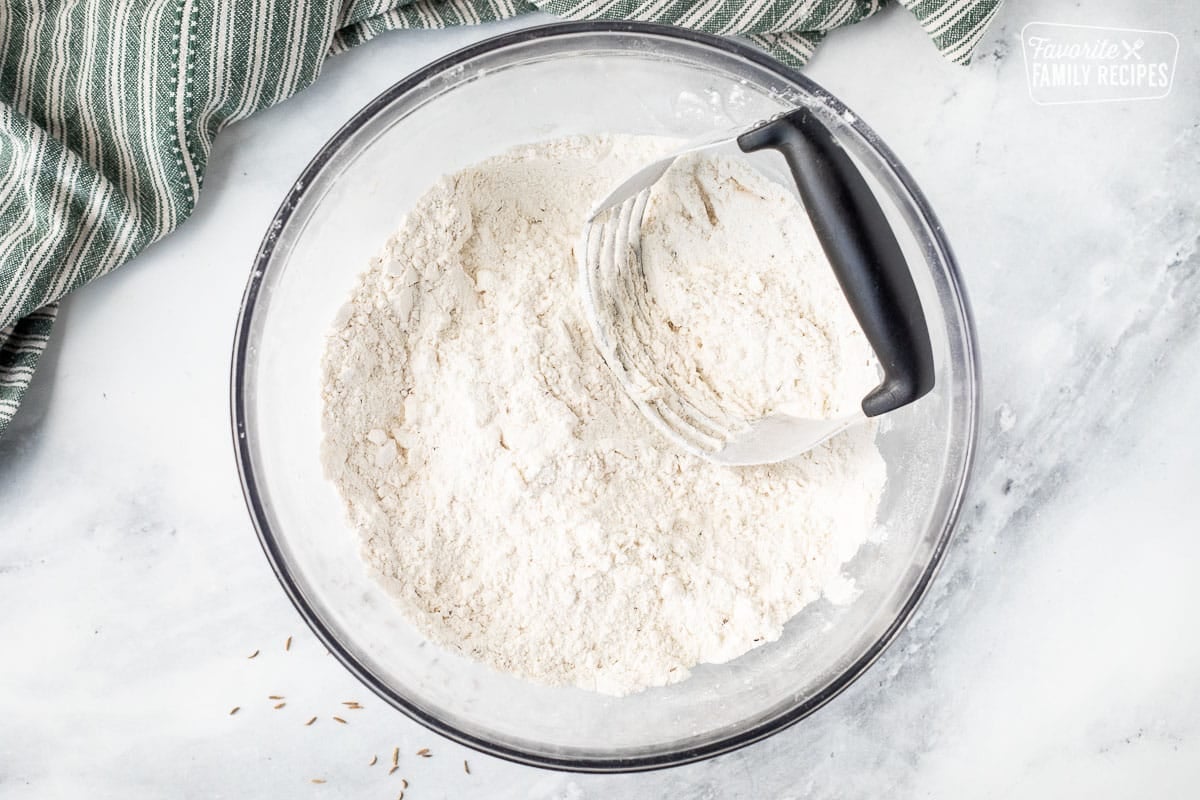 Bowl with butter cut into dry ingredients with a pastry blender.