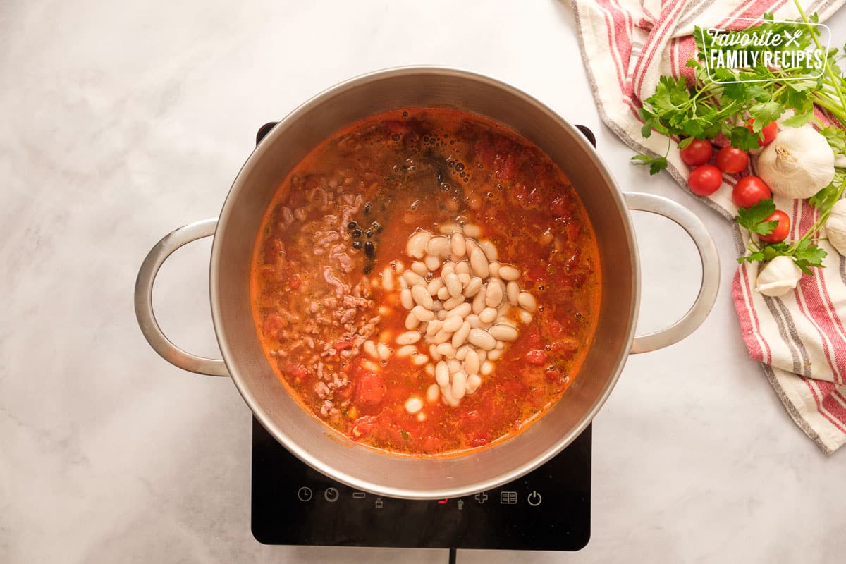 Italian sausage chili with beans in a large pot on an electric stove top.