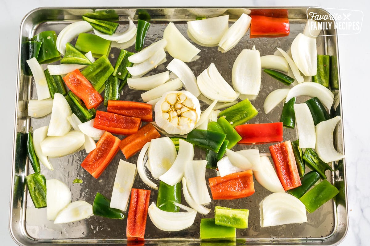 peppers, onions, and garlic on a baking sheet