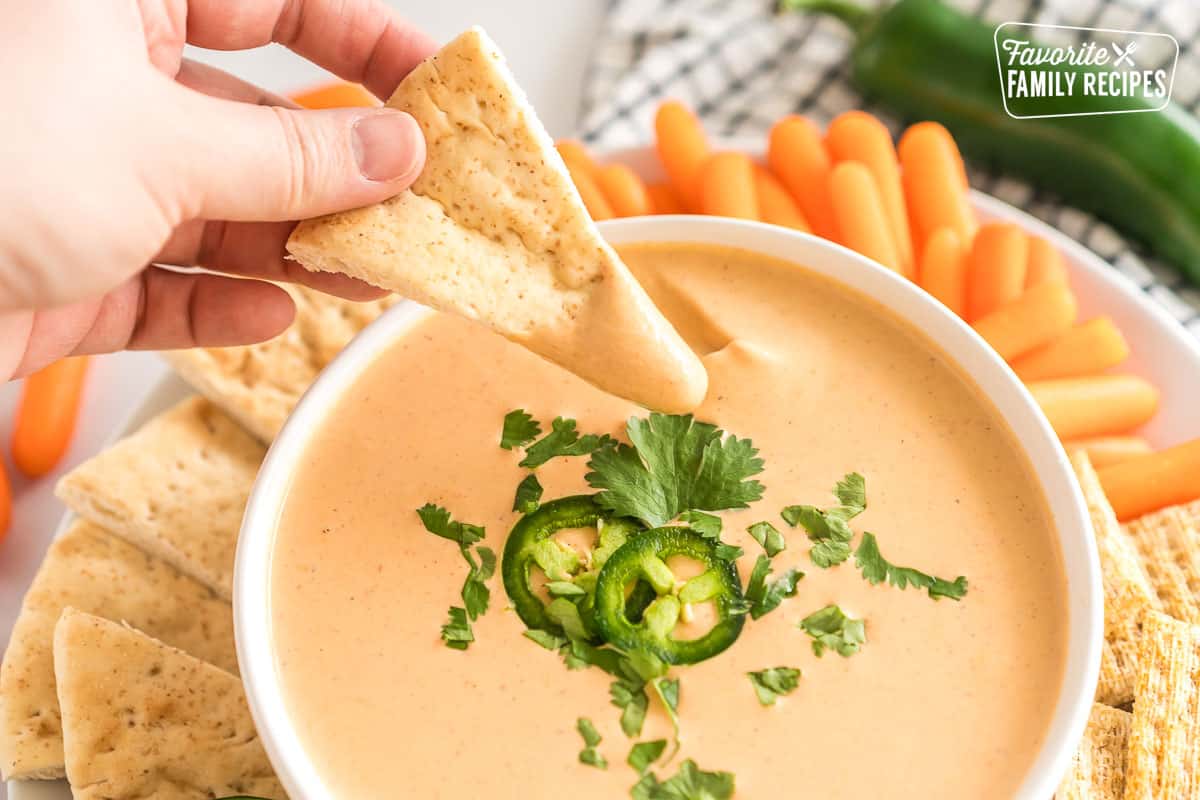 A slice of pita being dipped in jalapeno dip