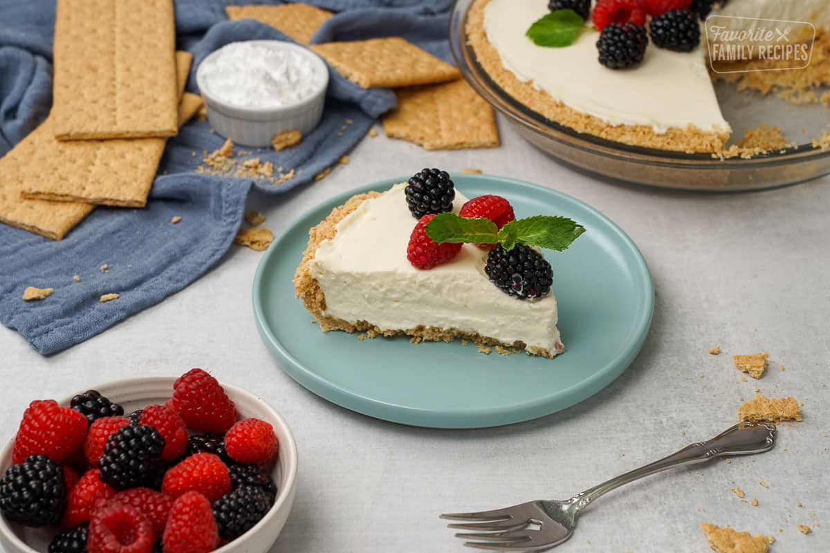 A slice of no bake cheesecake on a plate with berries.