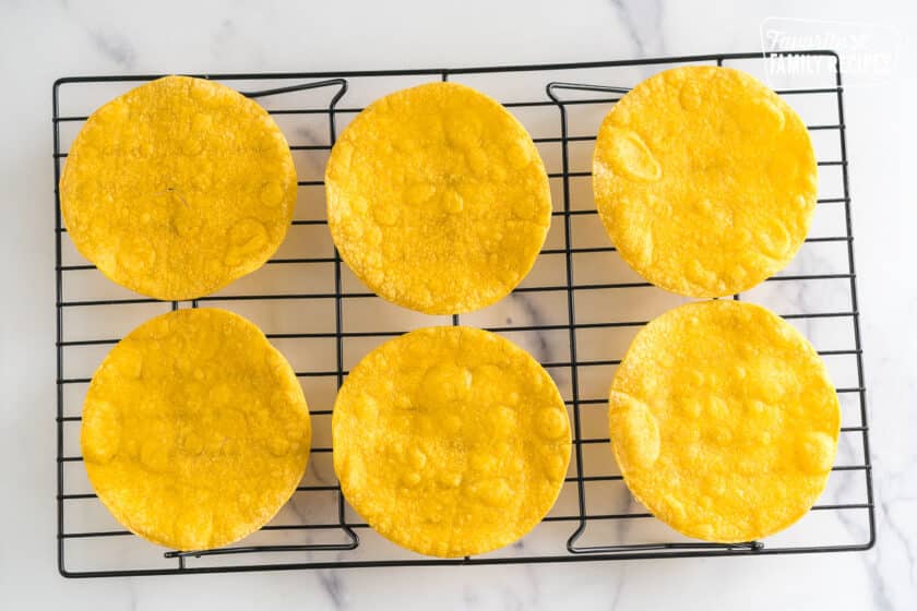 Cooked corn tortillas on a cooling rack