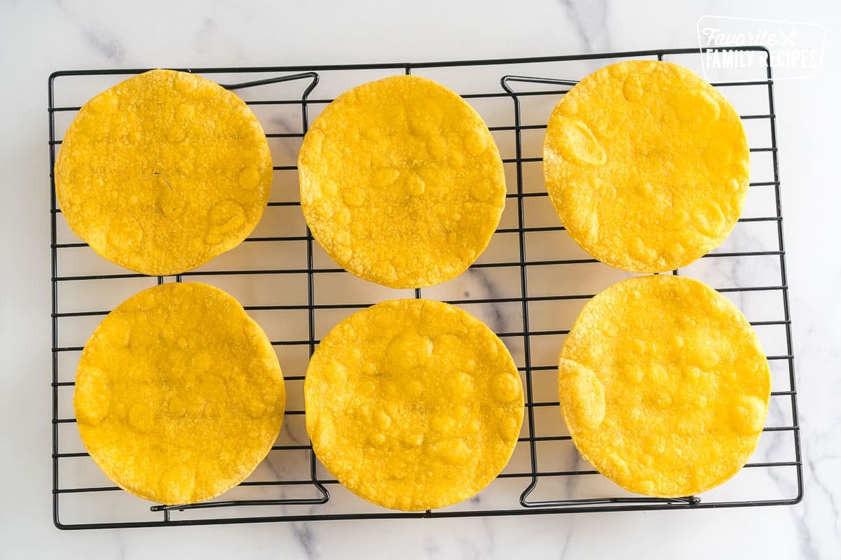 Cooked corn tortillas on a cooling rack