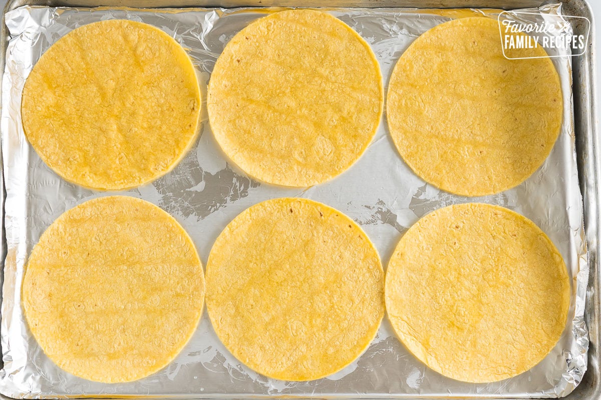 Corn tortillas lightly brushed with oil on a foil lined baking sheet