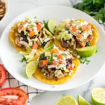 Three shredded pork tostadas on a plate