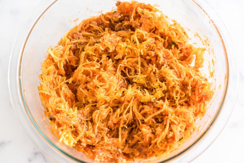 Spaghetti squash noodles mixed with red sauce in a glass bowl