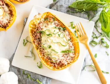 A Spaghetti Squash Lasagna on a plate topped with fresh basil