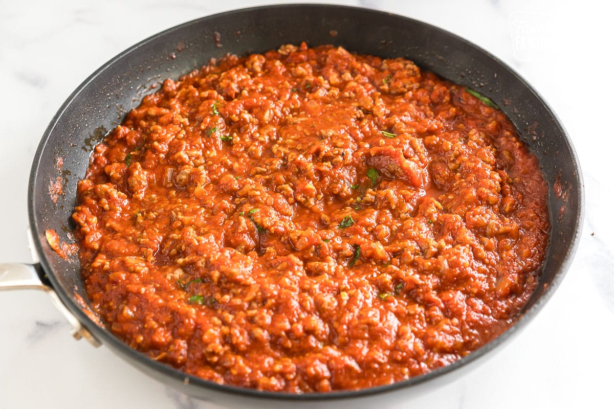 Tomato sauce with sausage in a skillet.