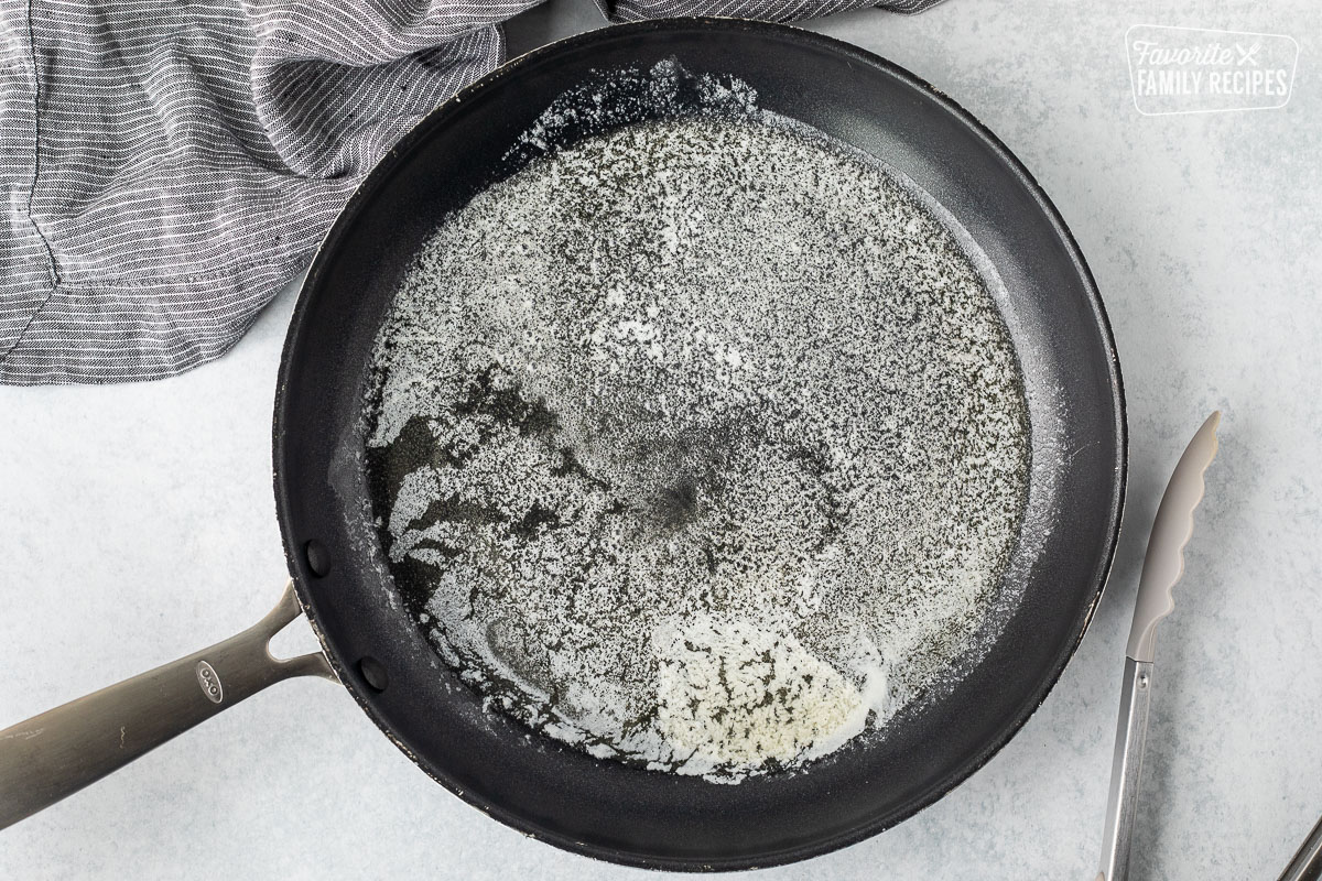 Skillet with melted butter and tongs.