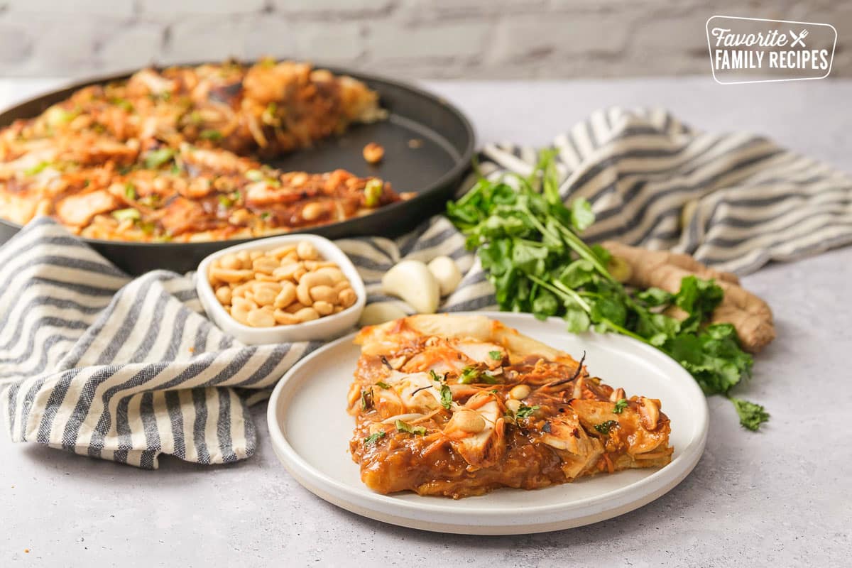 Thai chicken pizza on a white plate. 