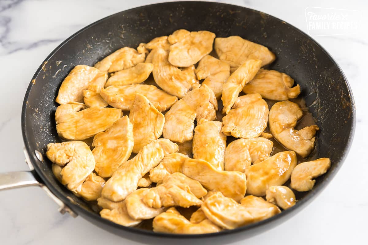 chicken cooking in peanut sauce in a skillet