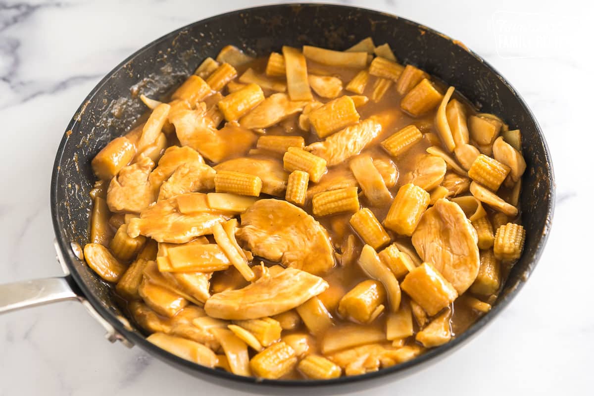 Chicken, peanut sauce, baby corn, and bamboo shoots in a skillet