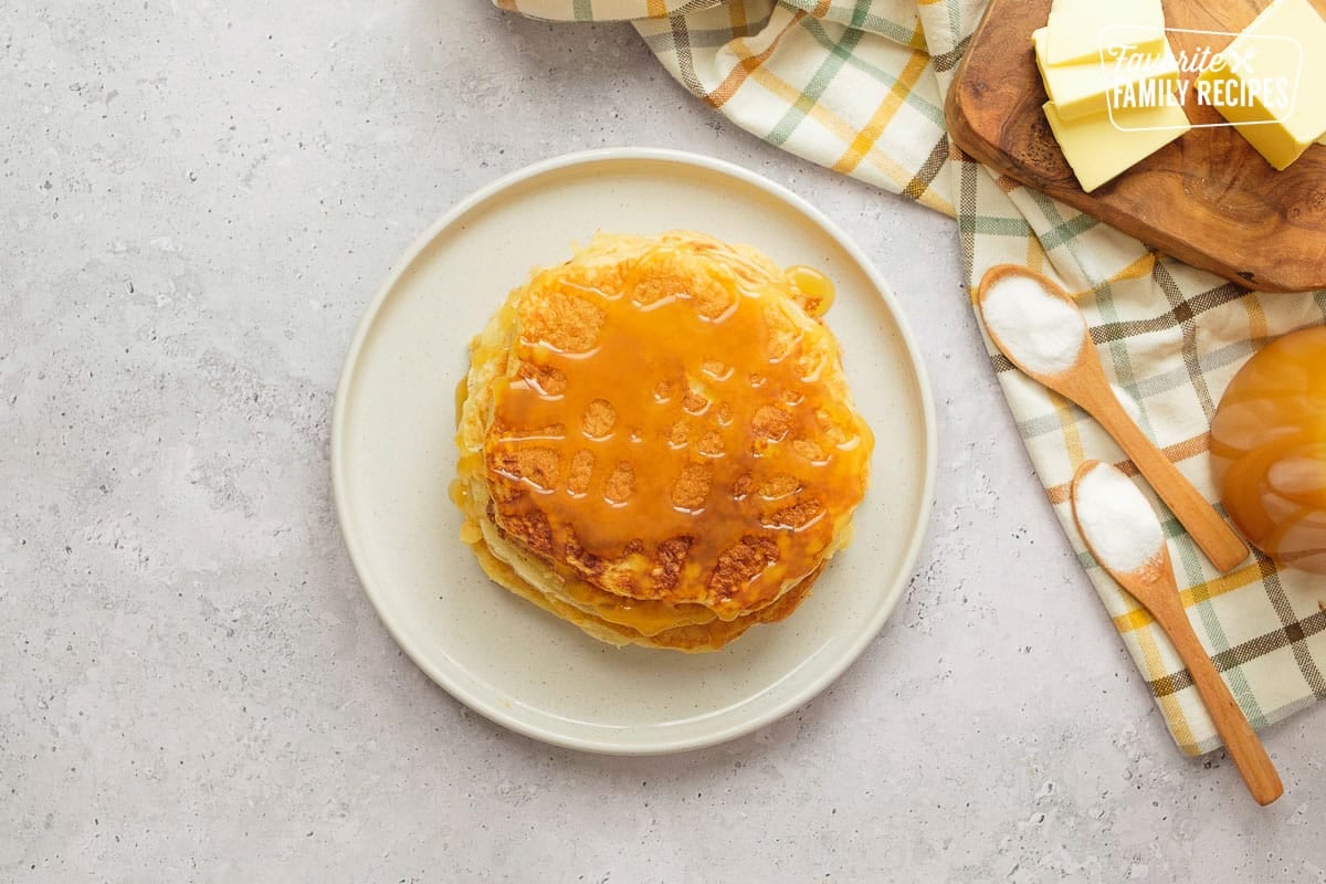 A photo of the pancakes from above on a white plate with syrup. 