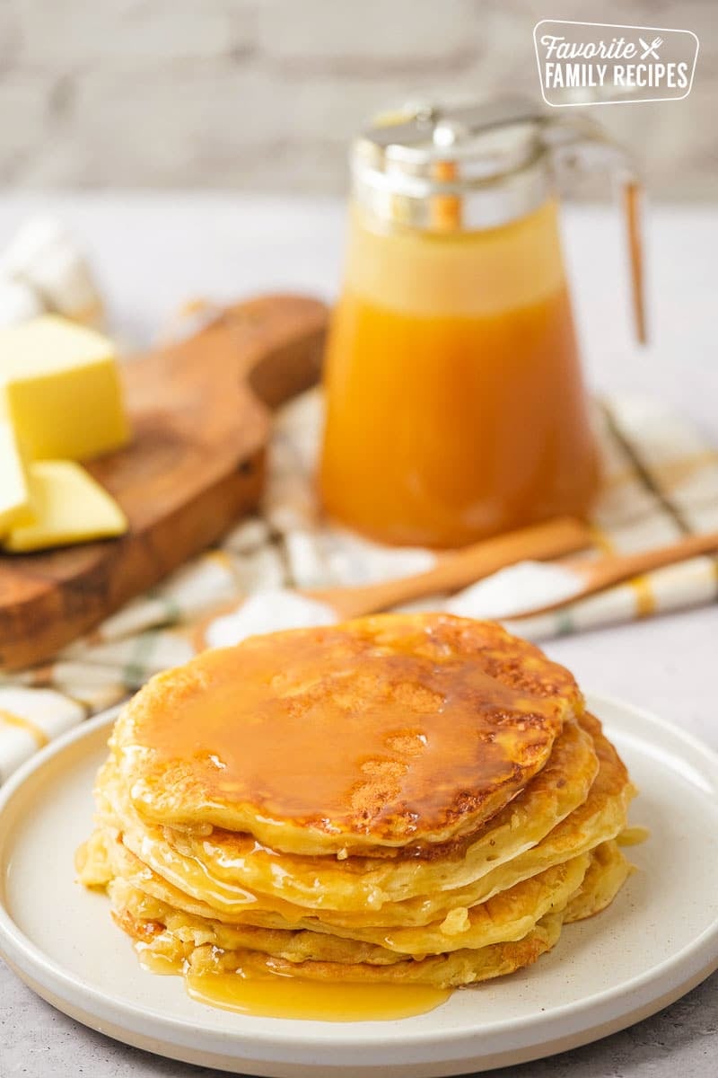 Yogurt pancakes with syrup drizzled on top of a white plate. 