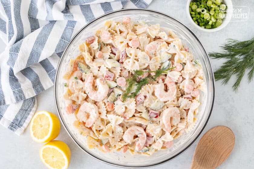 Glass bowl of Shrimp Pasta Salad garnished with fresh dill.