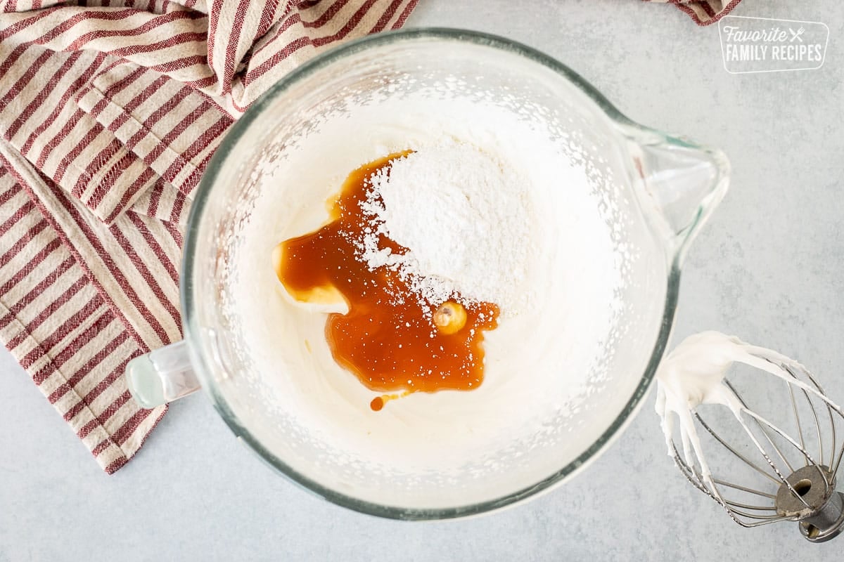 Heavy cream in a mixing bowl with butterscotch extract and powdered sugar mixed in.