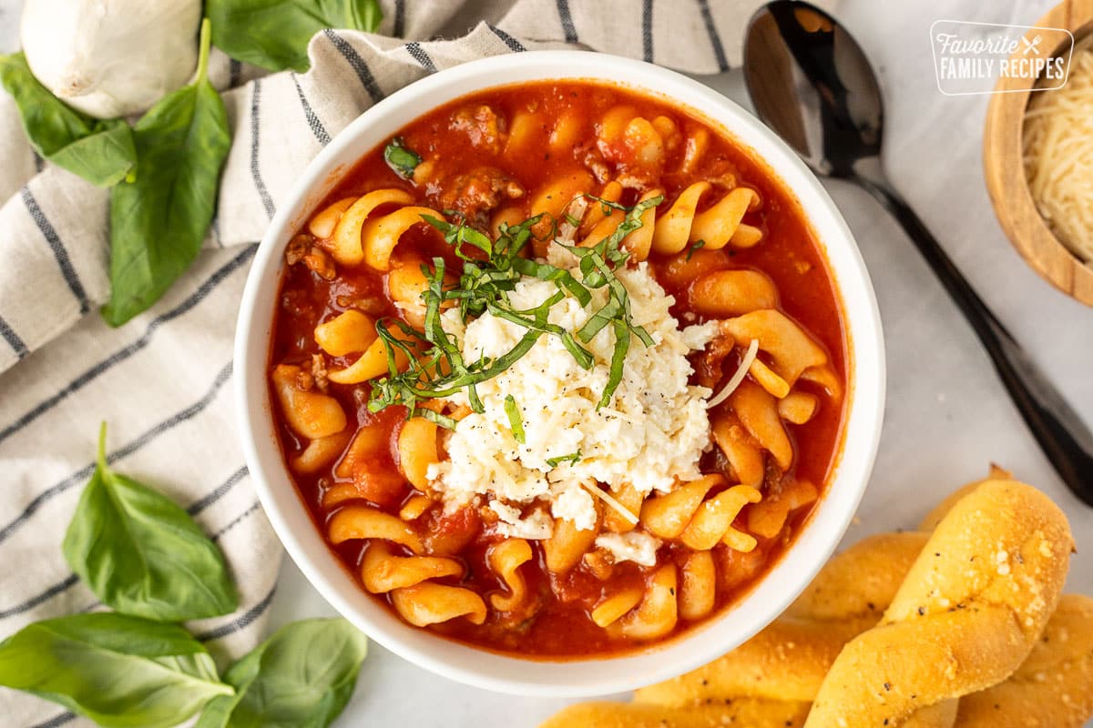 Close up bowl of Lasagna Soup with cheese and basil.