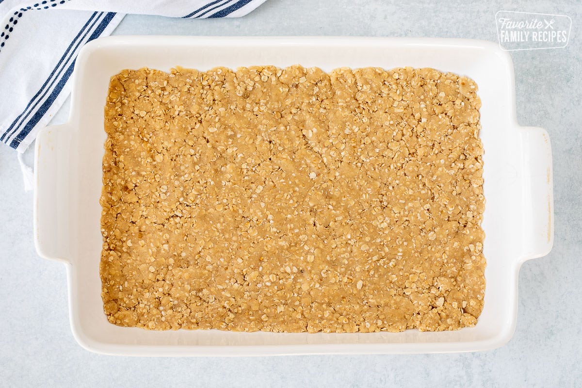 Baking dish with pressed cookie bar crust.