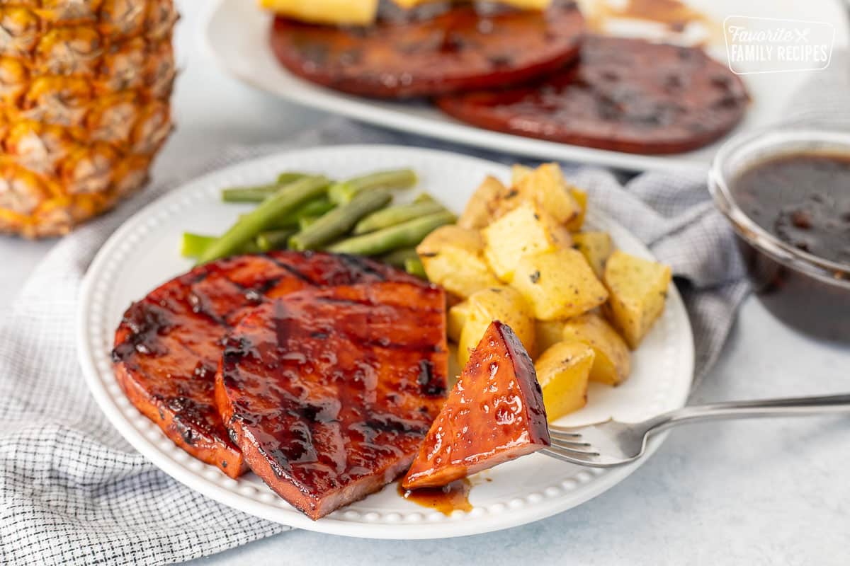 Cut piece of sweet teriyaki ham steak on a fork.