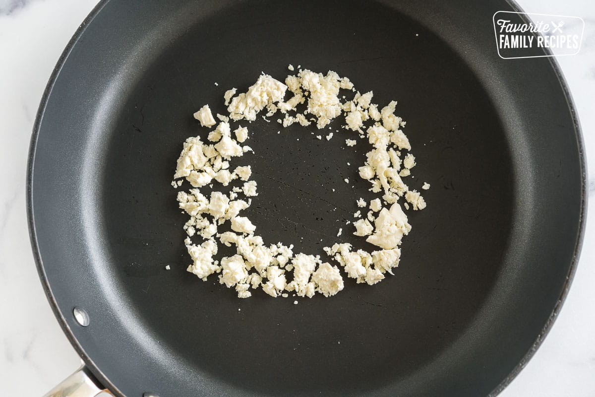 A ring of crumbled feta cheese in a pan