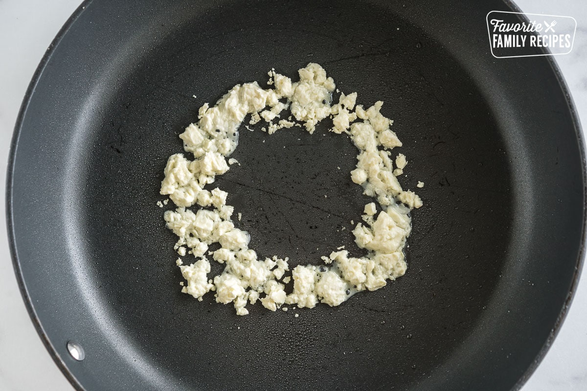 A ring of melted feta cheese in a pan