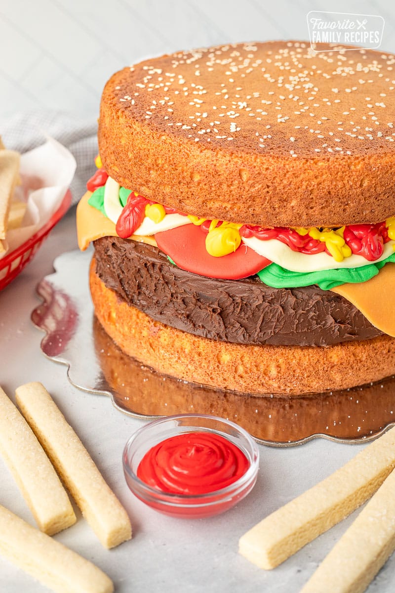 Hamburger fondant cake with frosting and cookie fries.