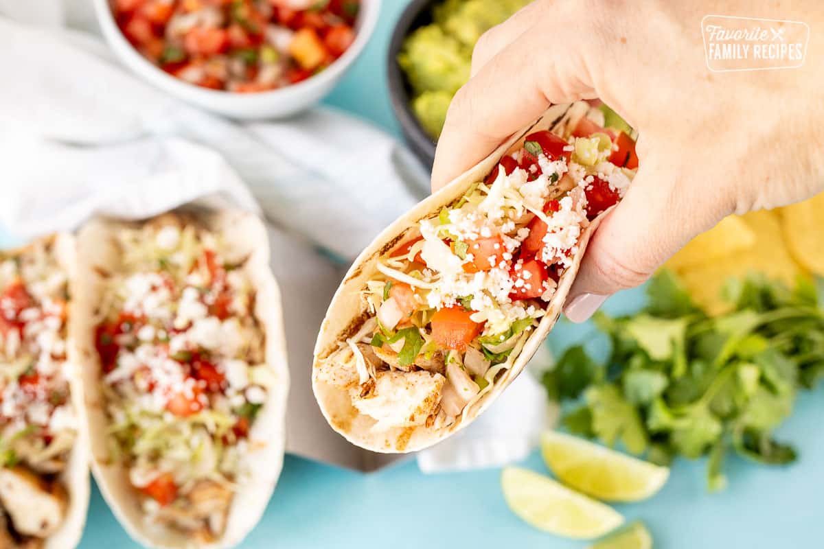 Hand holding a grilled Mahi Mahi Taco.