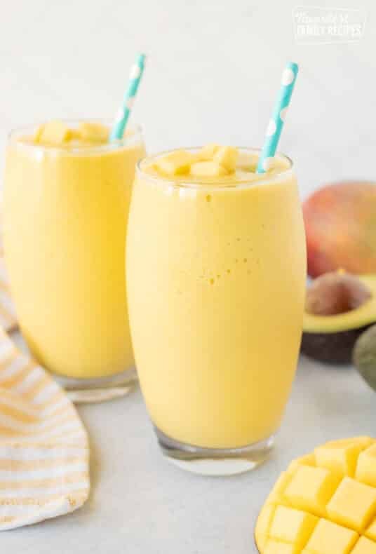 Two Mango Avocado Smoothies with straws.