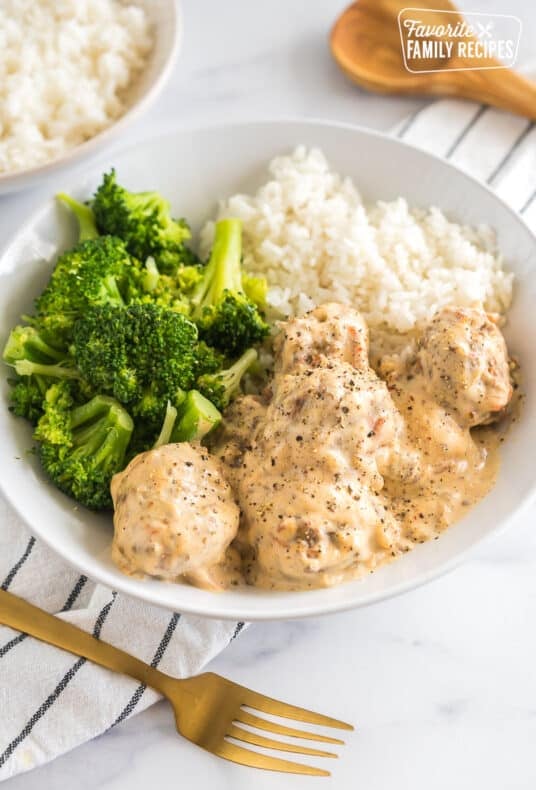 A bowl of Meatballs in Cream Sauce with broccoli and white rice