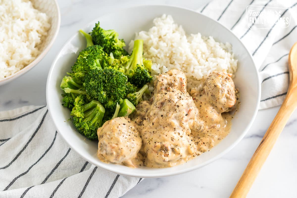 A bowl of Meatballs in Cream Sauce with broccoli and white rice
