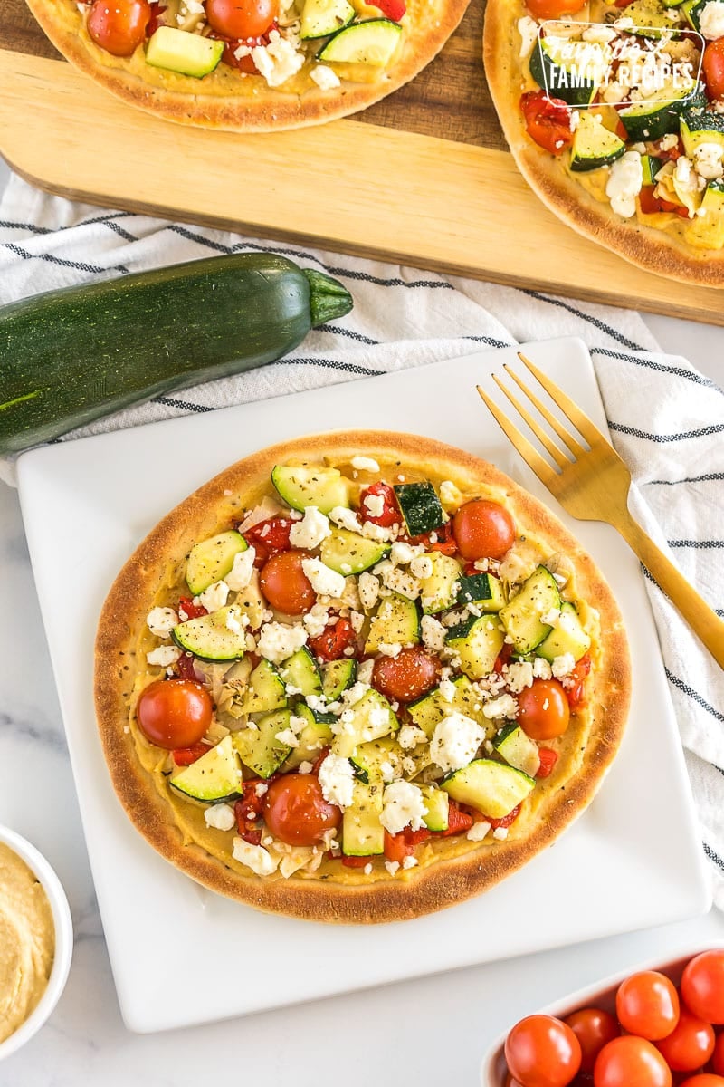 Mediterranean Flatbread Pizzas are crisp and bursting with flavor. They're the perfect snack or lunch and are ready in a few short minutes! A Mediterranean flatbread pizza on a plate