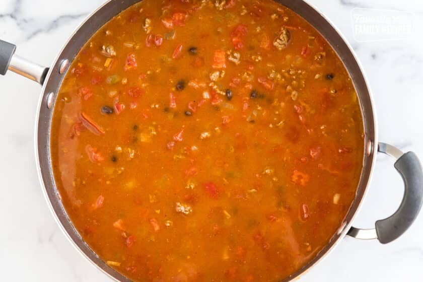 A large pan full of veggies, meat, and broth
