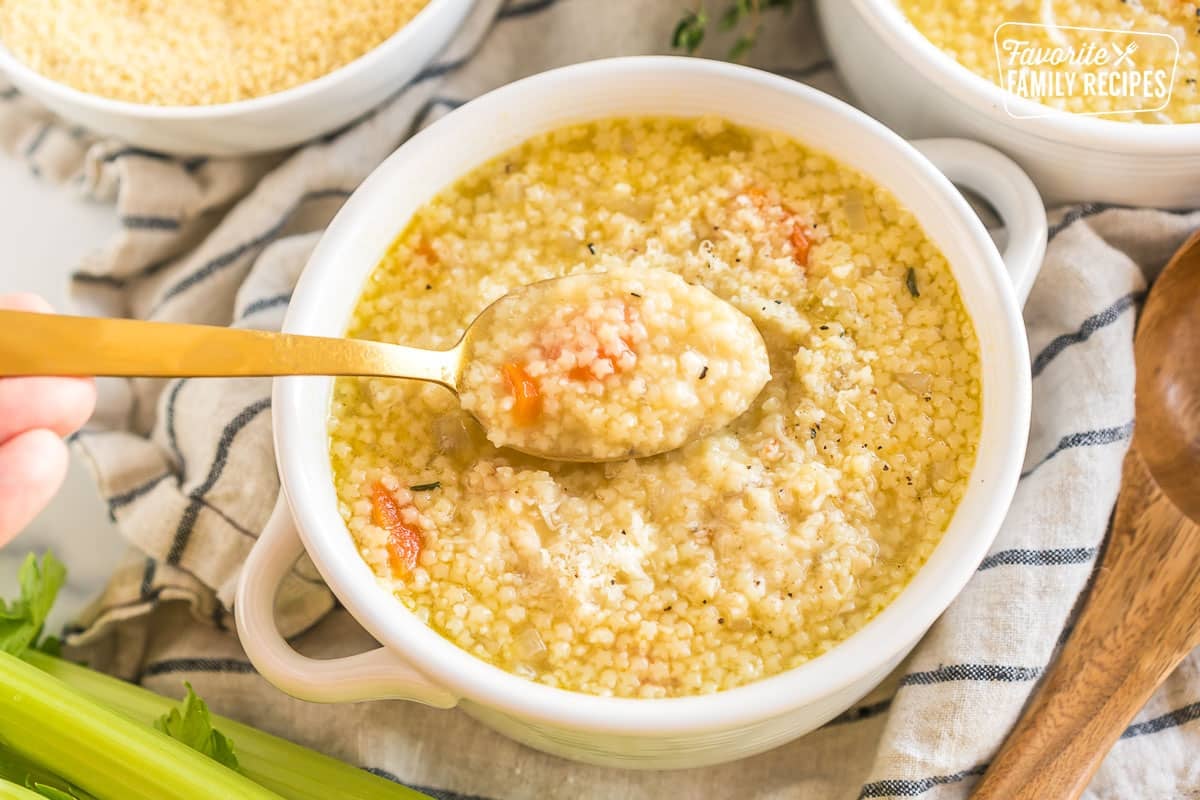 A spoonful of pastina soup being scooped out of a bowl