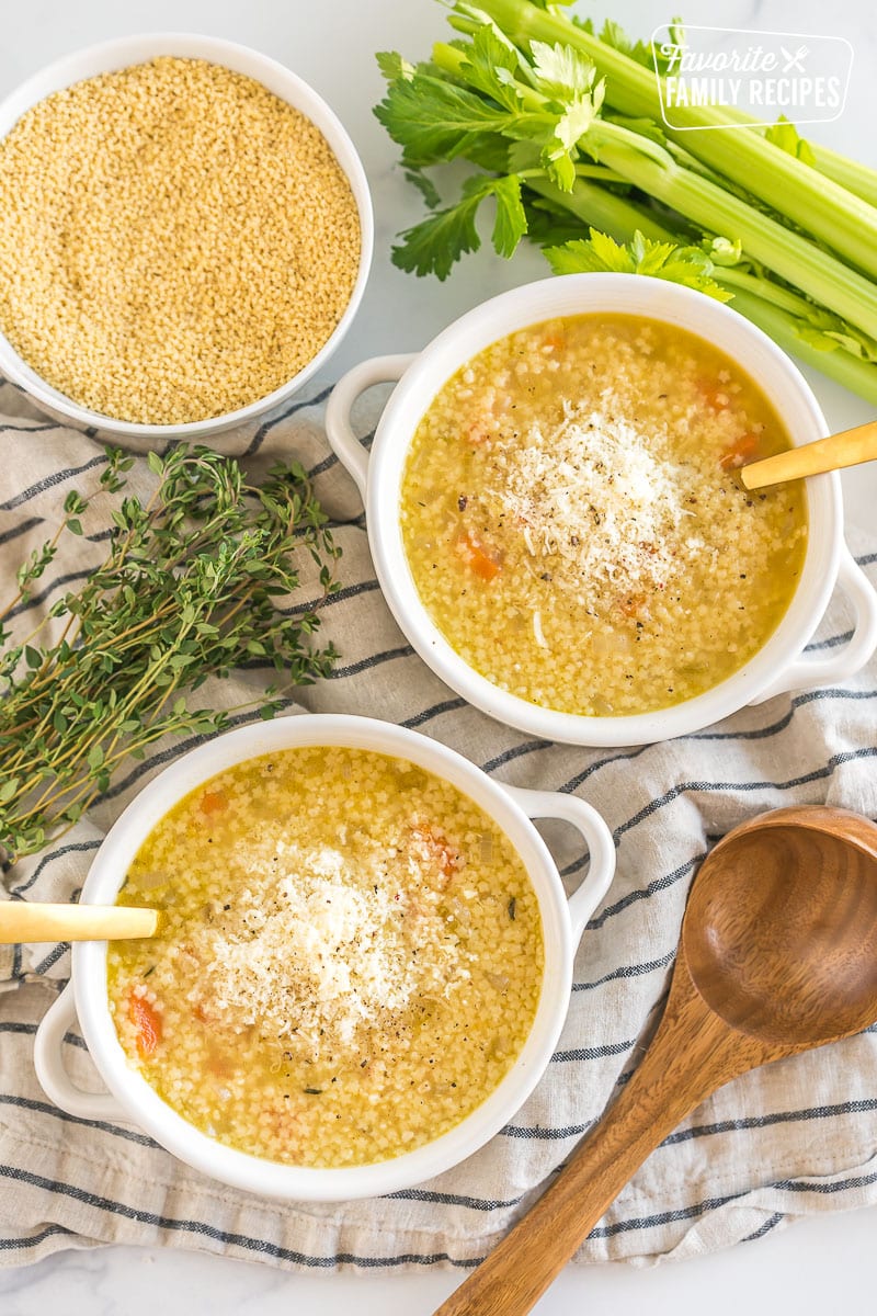 Two bowls of Pastina Soup topped with cheese and pepper