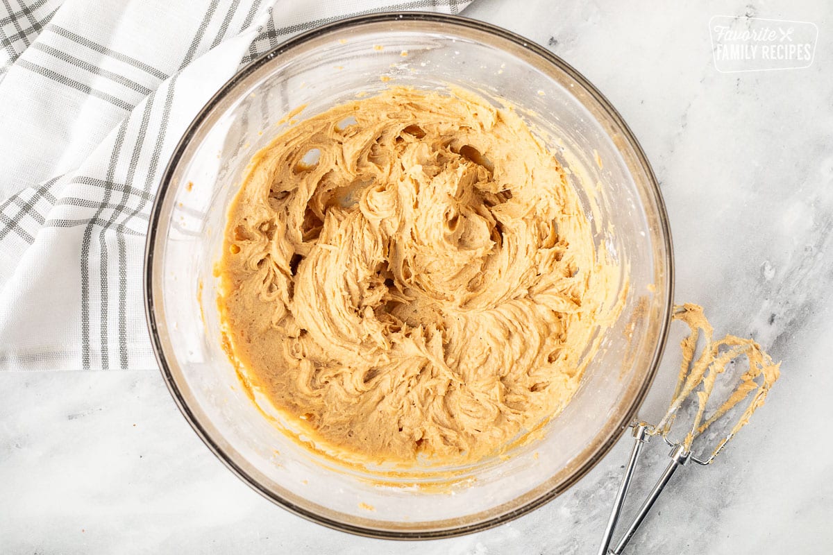 Mixing bowl with whipped peanut butter. Electric beaters on the side.