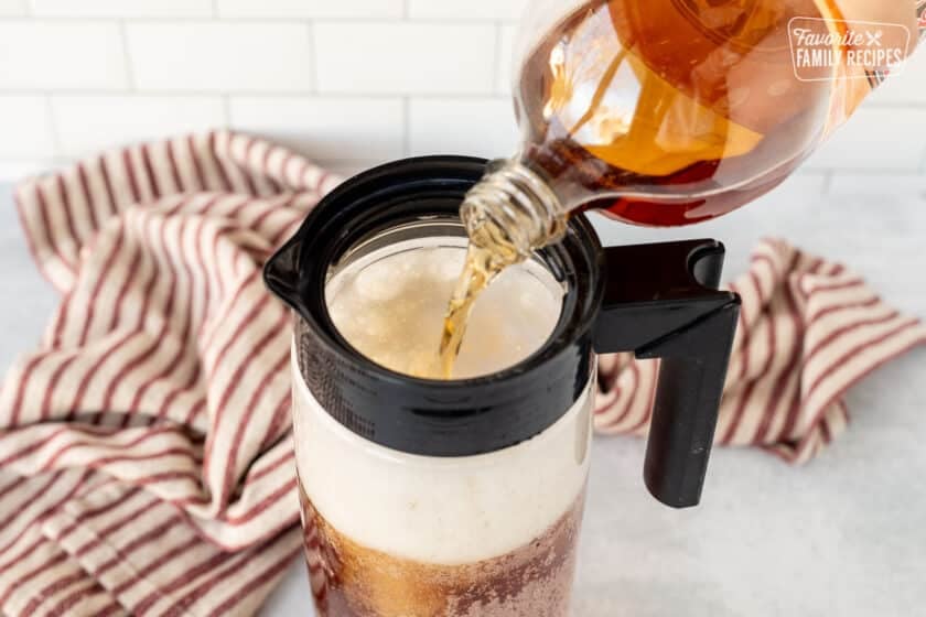 Cream soda being poured into a mug to make Butterbeer.