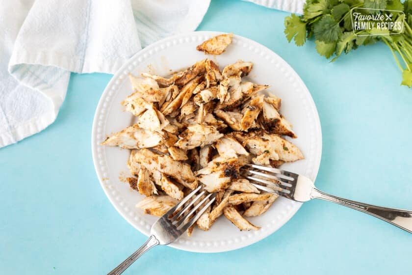 Plate with shredded mahi mahi fish and two forks.