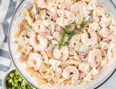 Bowl of Shrimp Pasta Salad with fresh dill, lemon and green onions.