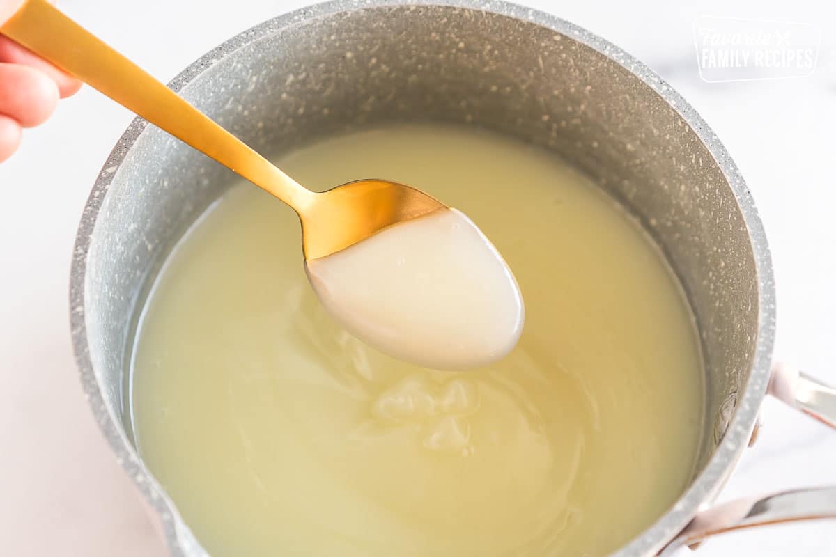 Custard base being scooped with a spoon out of a pot