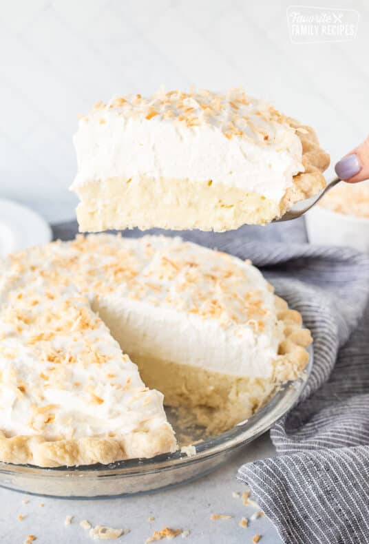 Holding up a slice of Coconut Cream Pie on a spatula.