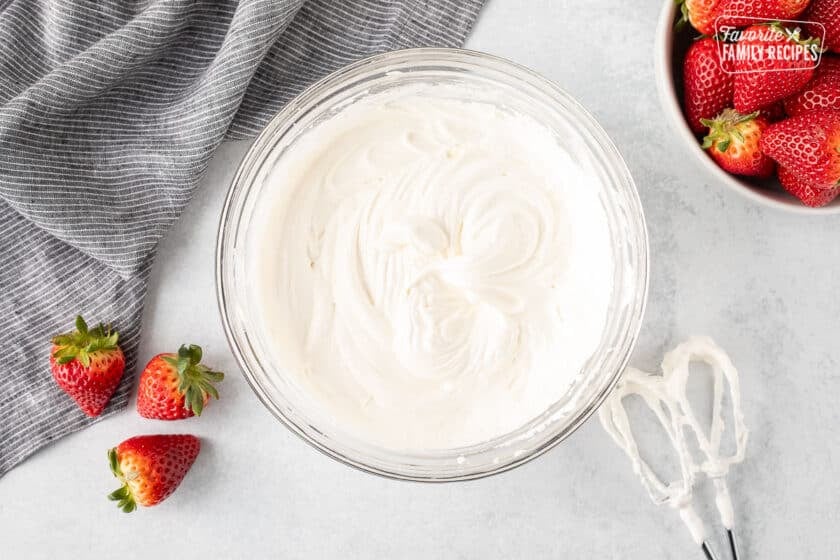 Bowl with whipped cool whip and cream cheese. Mixing beaters on the side.