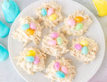 White Chocolate Bird Nests on a plate. Peeps and jelly beans on the side.