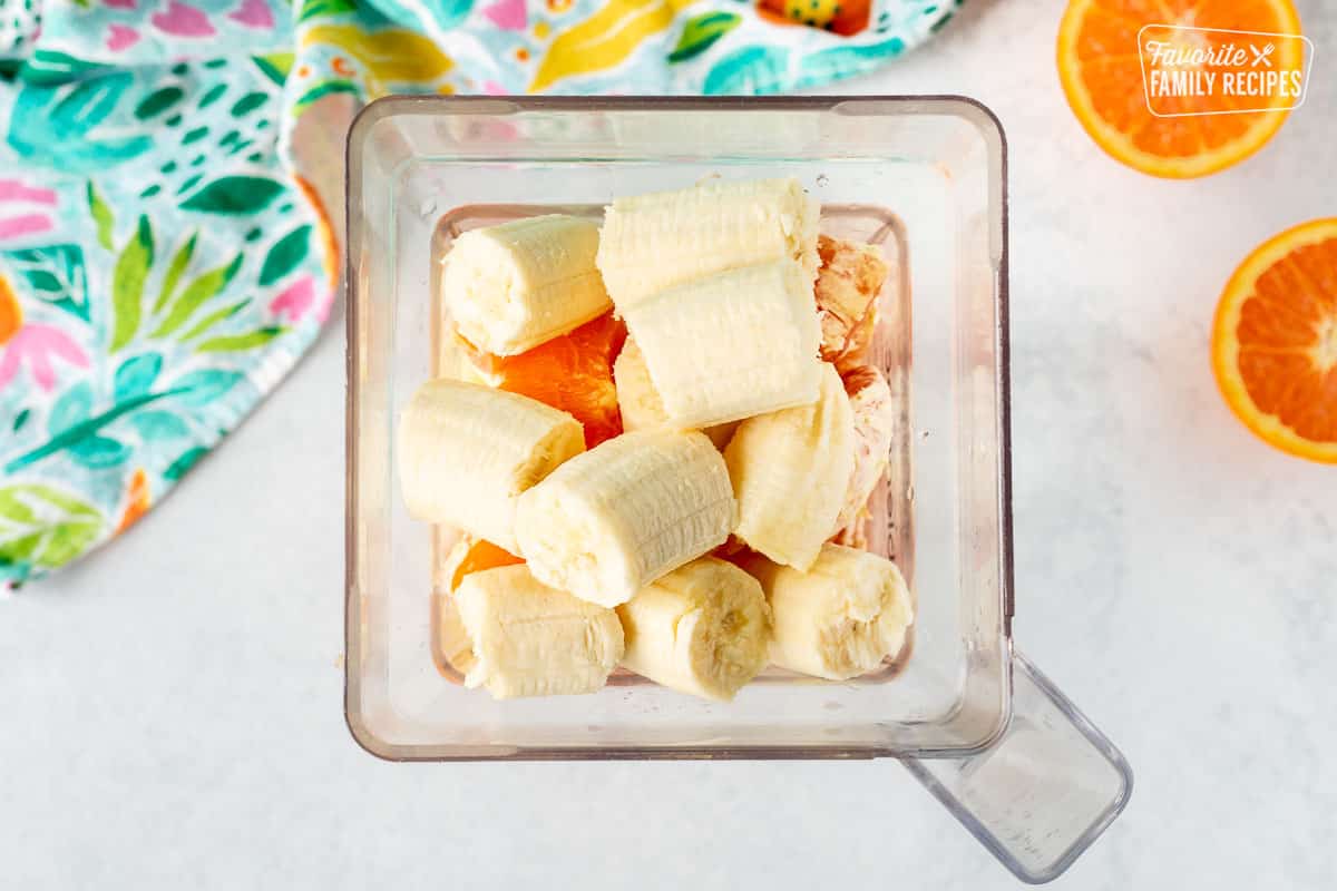 Blender with frozen pineapple, oranges, orange juice and bananas.